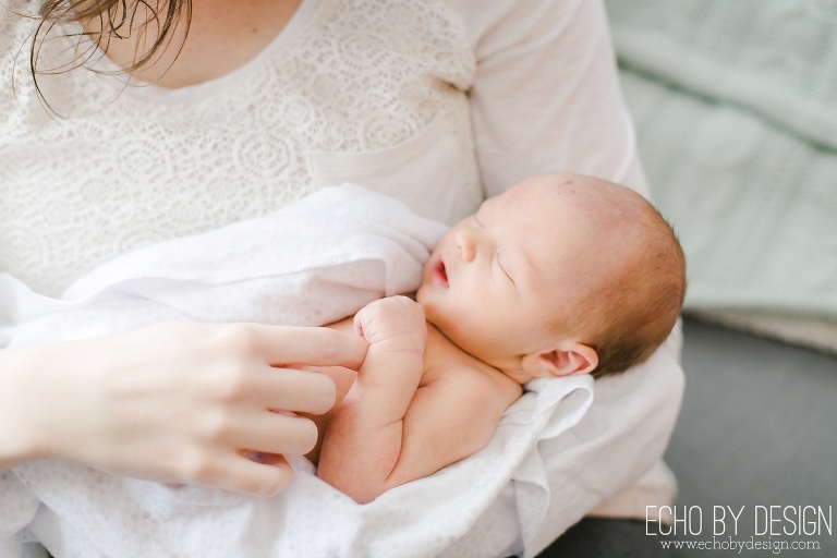 Mom holds newborn son, newborn holding moms finger