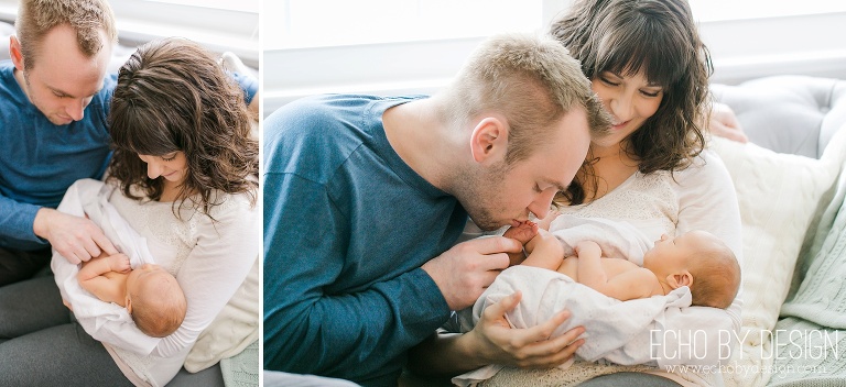 Dad kisses newborn sons toes on the couch in home