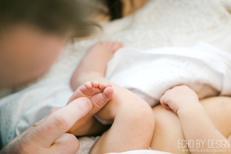 Dad plays with newborn son toes
