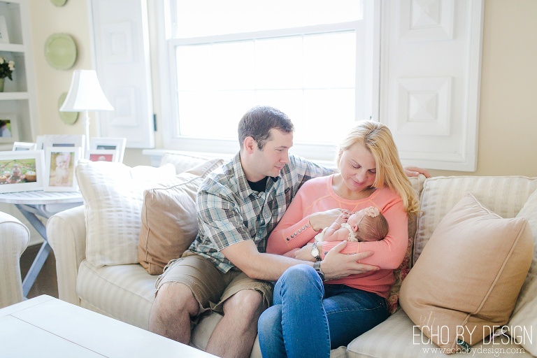 Parents Cuddle on the Couch with Newborn