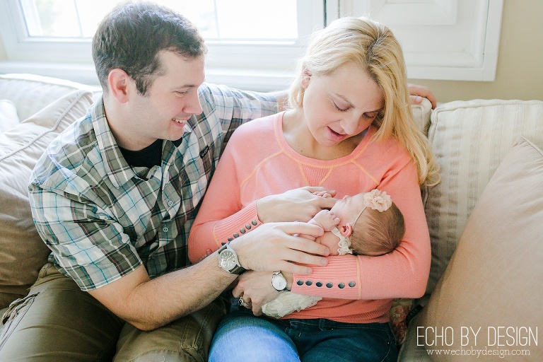 Parents on couch with newborn baby